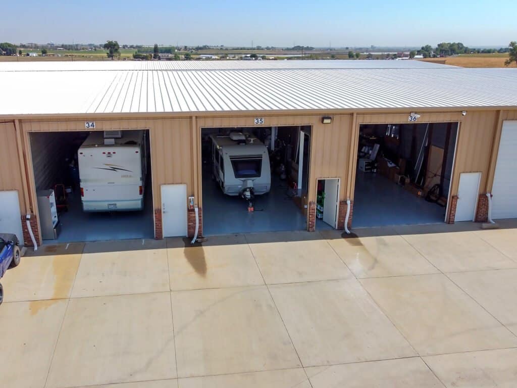 Mead_Garages_OpenBays Drone image of Outrig's Mead Garages Enclosed Storage with garage doors open featuring parked RVs