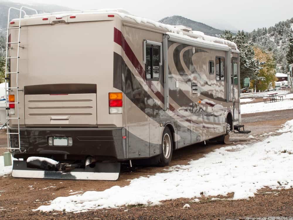 Class A RV parked at a snowy campsite