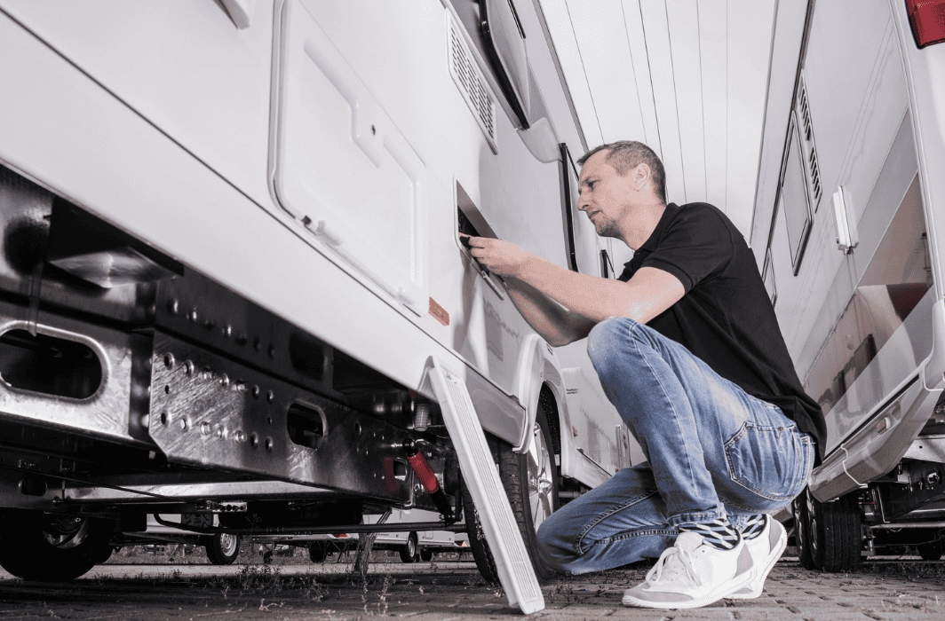 RV technician removes a panel on the side of an RV to prepare for Outrig RV services