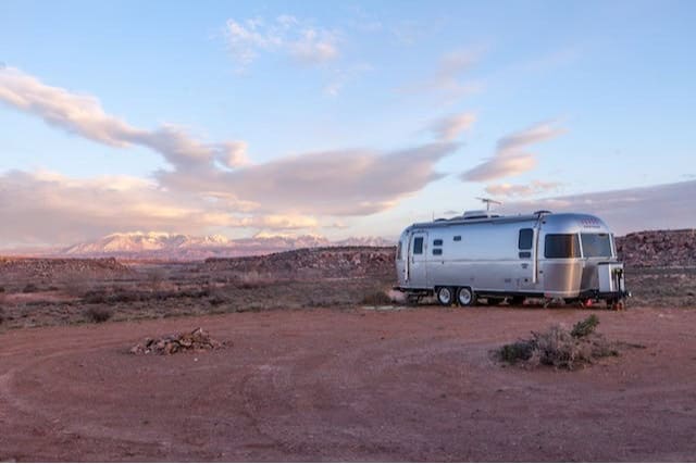 Airstream trailer parked in a southwestern landscape at sunset