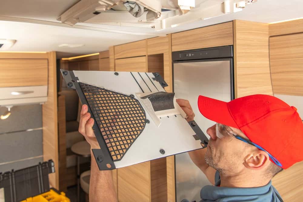 RV technician inspecting an AC vent inside of an RV.