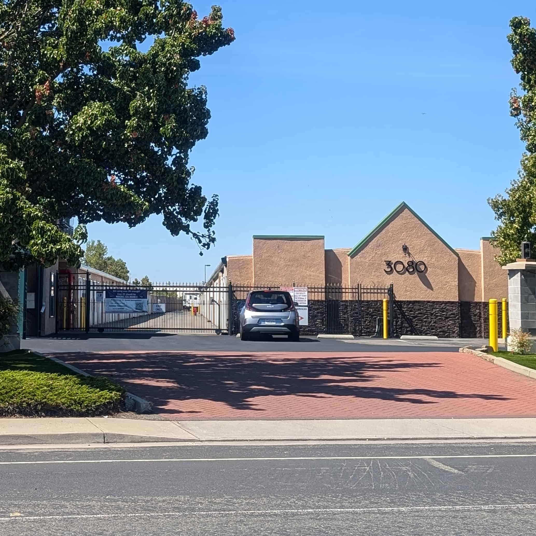 Front gate of storage facility with wide driveway.