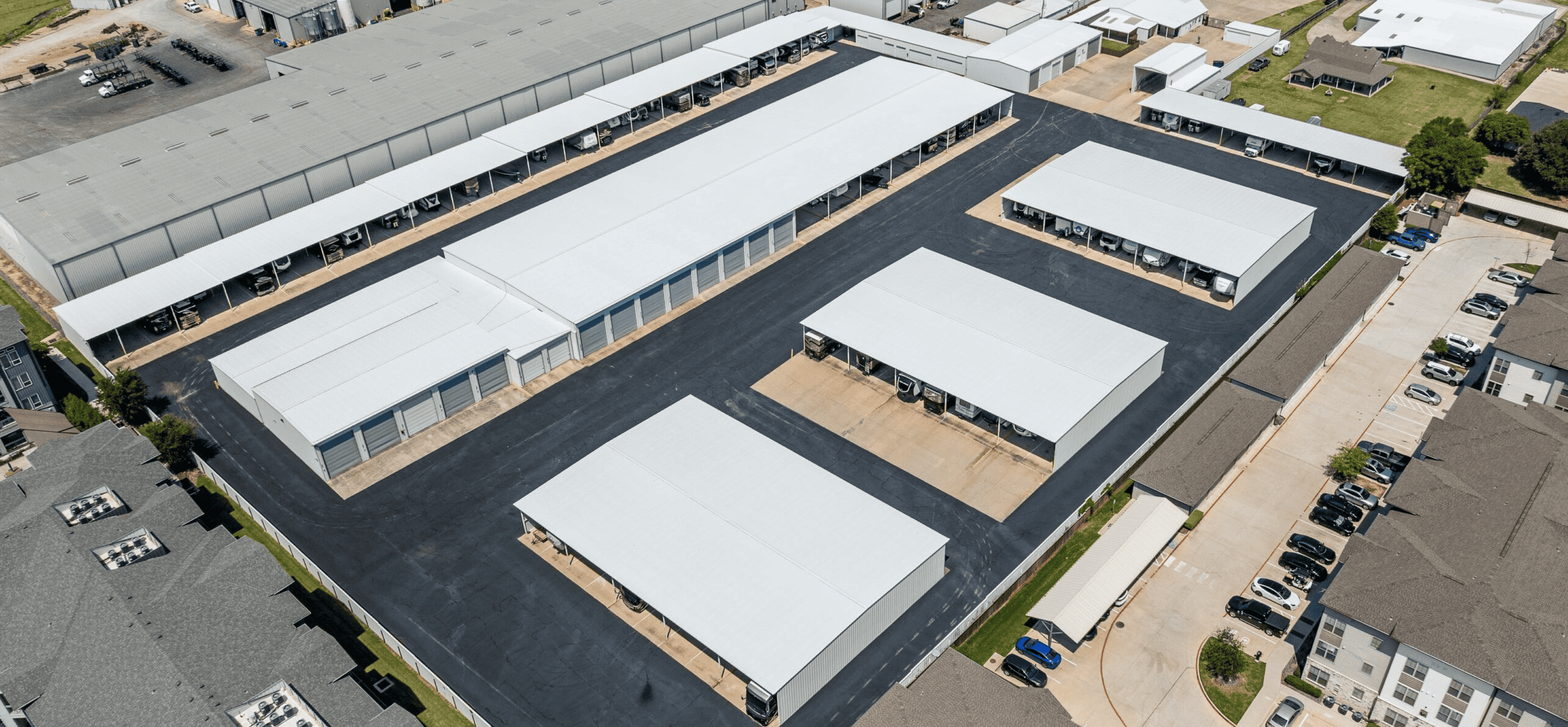 Modern industrial storage facility with multiple warehouse units and outdoor parking area.