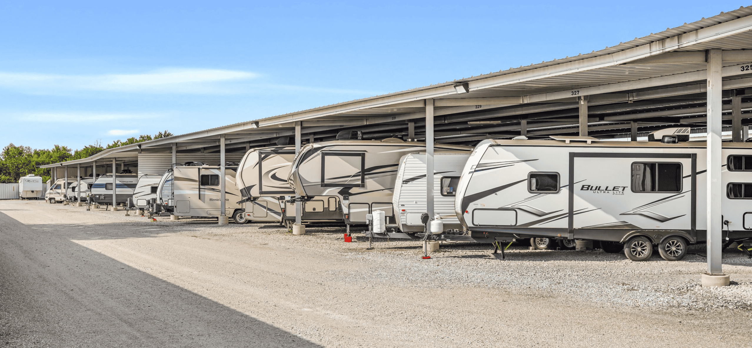 RV storage facility with covered parking for travel trailers and motorhomes.