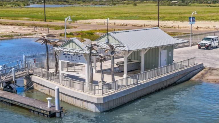 Boat slip marina at Lake Capo Christi, Texas with dock infrastructure and decorative palm trees.