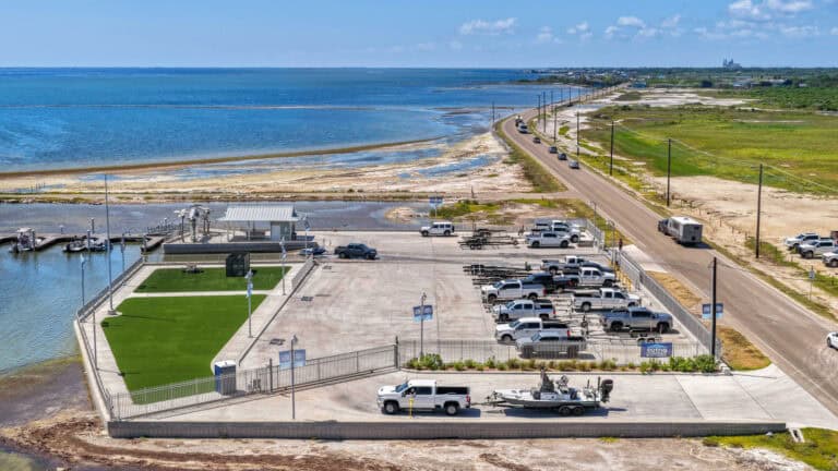 Modern waterfront parking lot with boat launch and scenic ocean view.