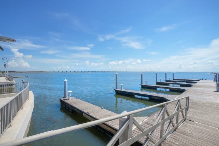 Dock and boat slips at a scenic waterfront marina with clear blue skies and calm water, perfect for boating and leisure activities.