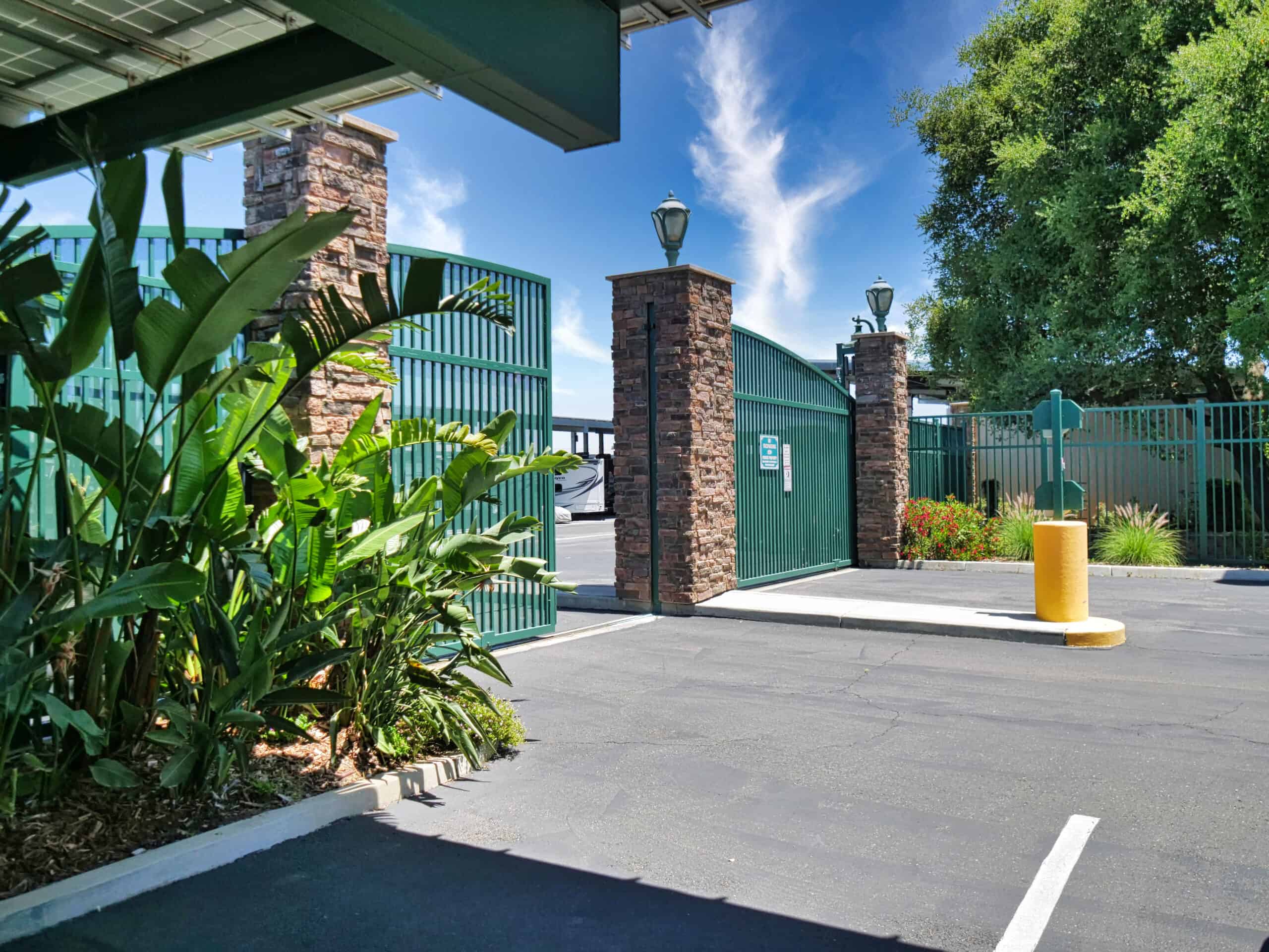 Oakley's front-gate with lush green plants around on a sunny day